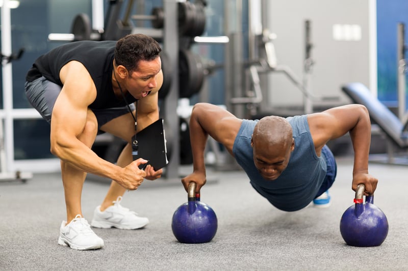 personal trainer pushing one more rep pushups